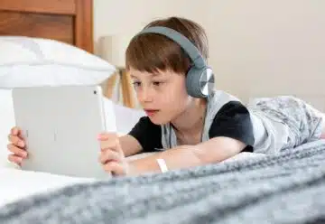 un enfant sur sa tablette avec un casque audio