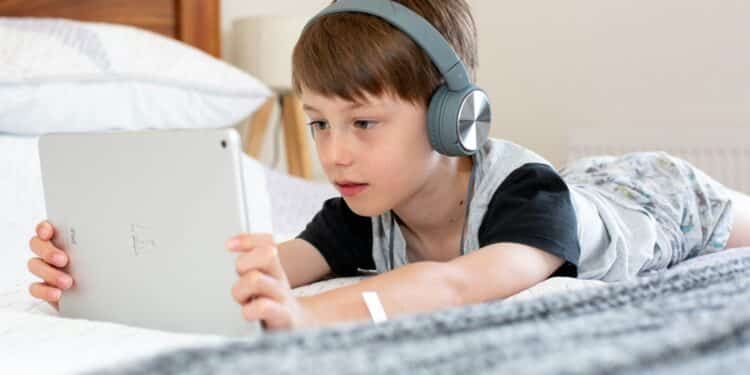 un enfant sur sa tablette avec un casque audio