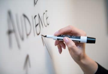 person holding white and blue click pen