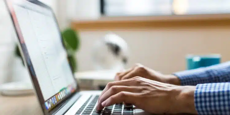 person typing on silver MacBook